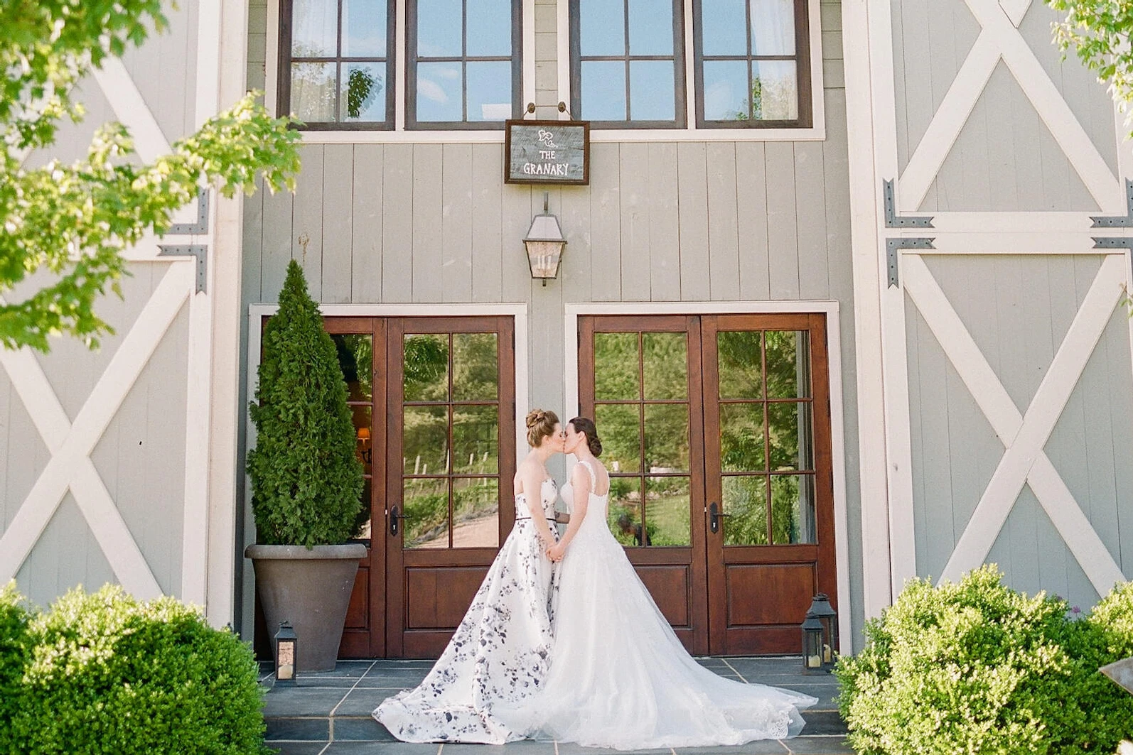 Pippin Hill Farm: Two brides kissing outside of a barn in Virginia.