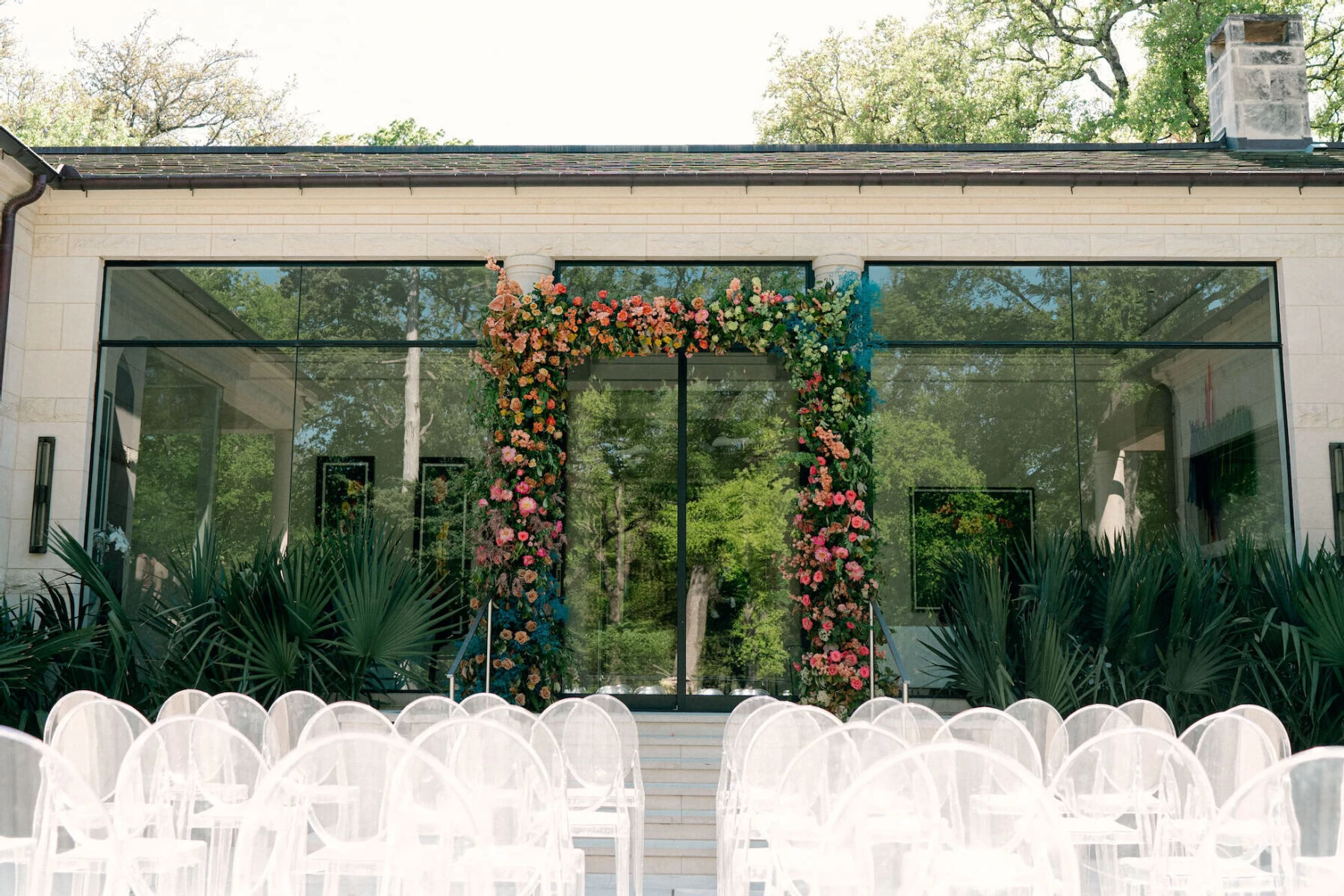 A colorful floral arch served as a focal point for this outdoor, rainbow wedding in Dallas.