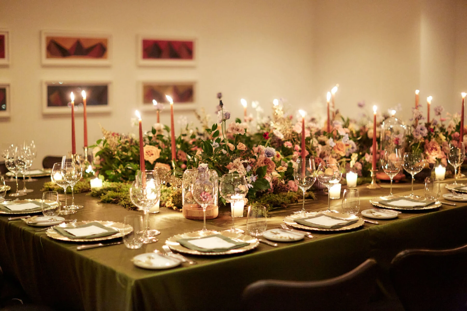 For this restaurant wedding, one long table held all the guests and was decorated with candles, moss, fresh flowers, and fresh fruit.