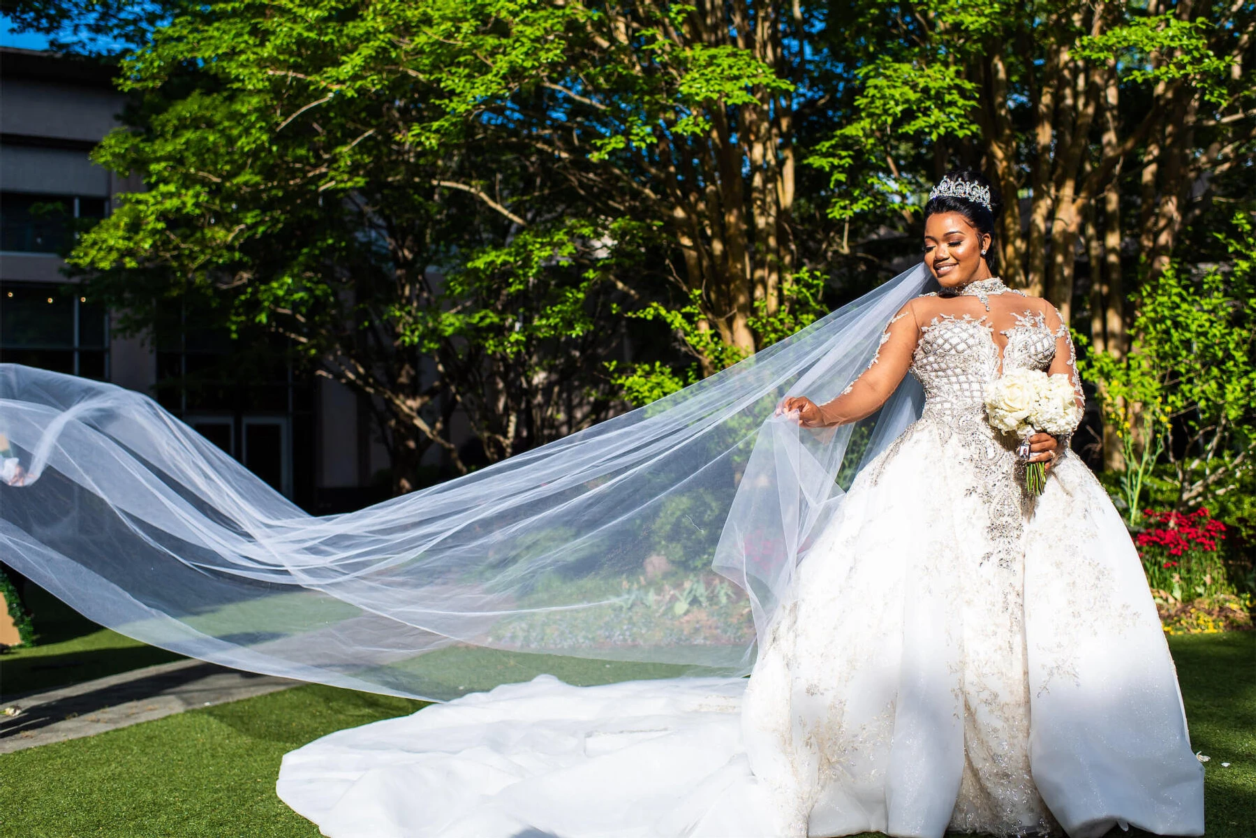 Royal Wedding Dresses: A bride outside holding a bouquet, with her long veil blowing in the wind.