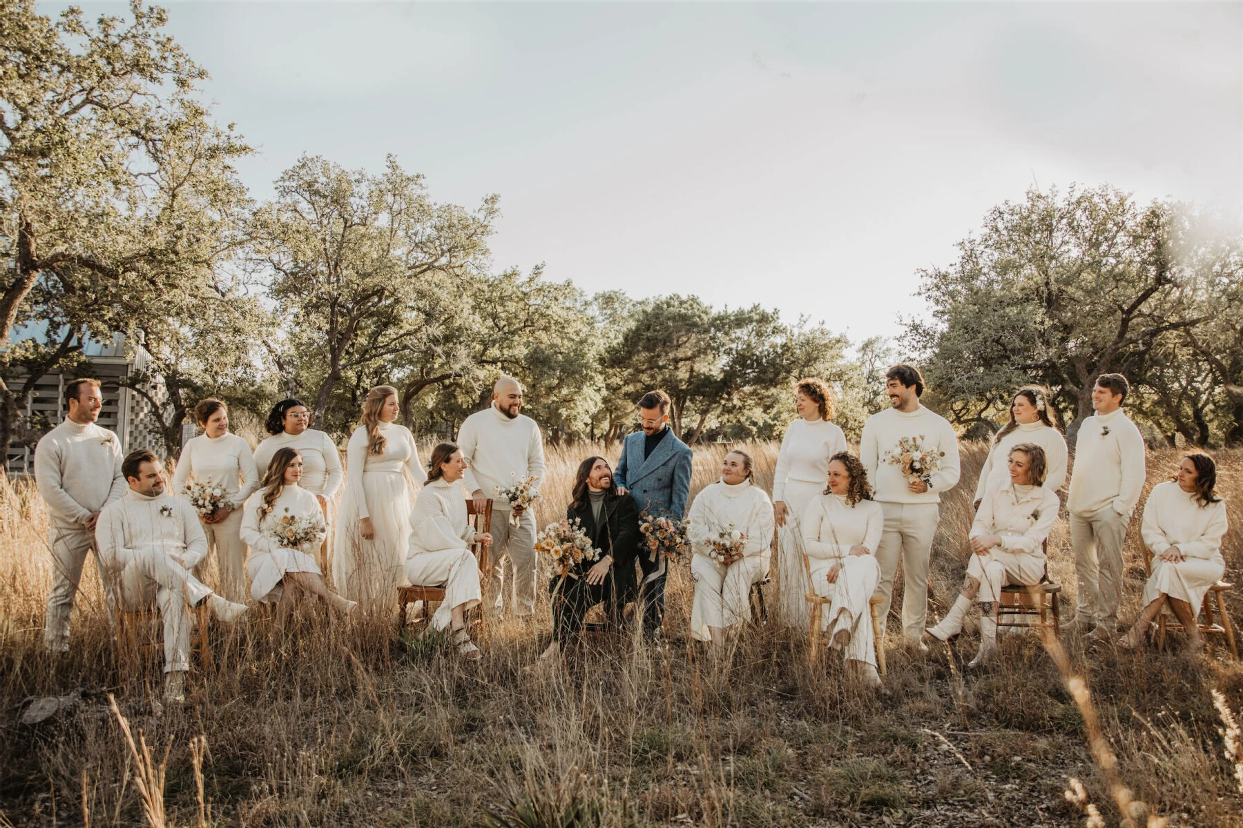 A portrait of an untraditional wedding party, where the attendants are in white and the couple is in color.