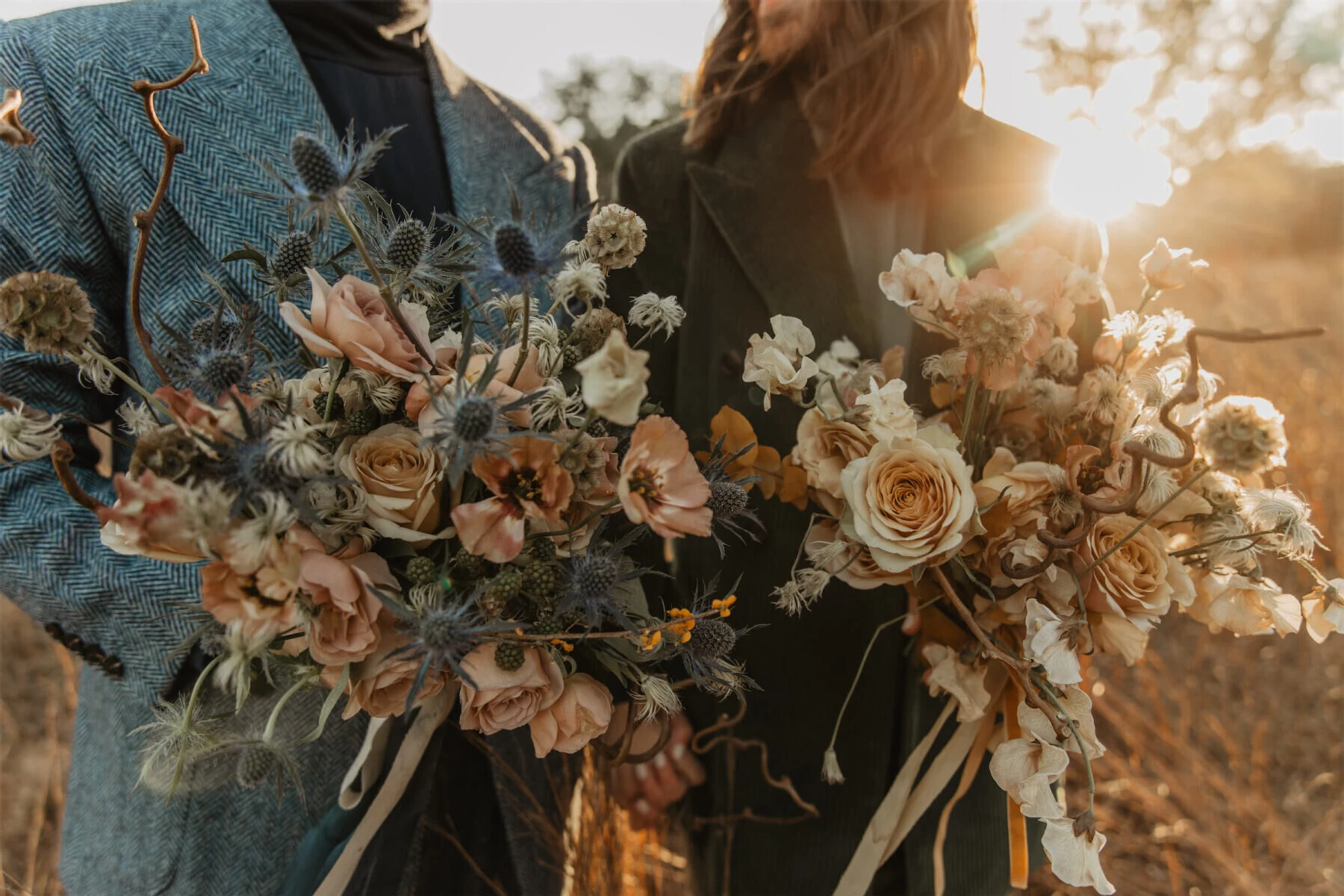 A pair of grooms hold their complementary bouquets inspired by their personalities and outfits at their untraditional wedding in Texas.