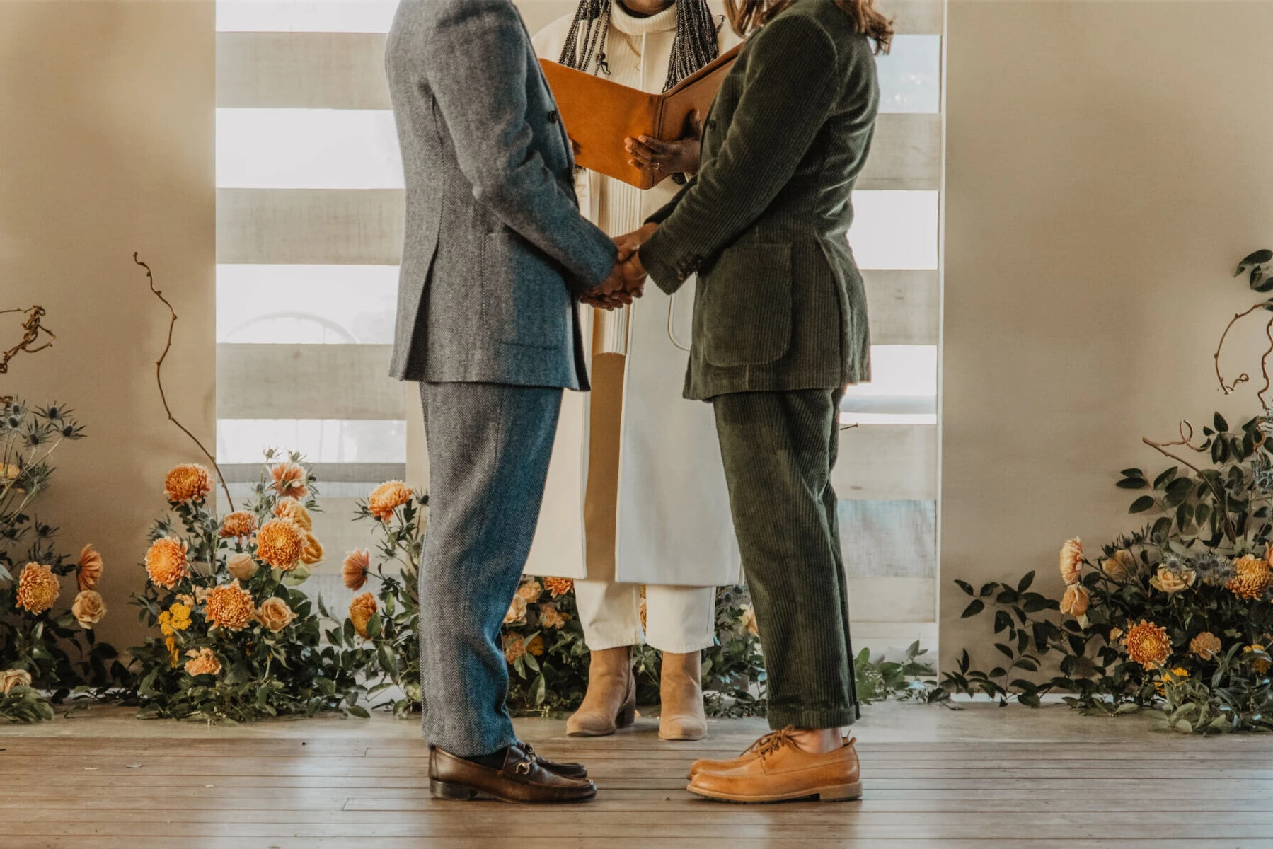 A couple holds hands during their untraditional wedding ceremony.