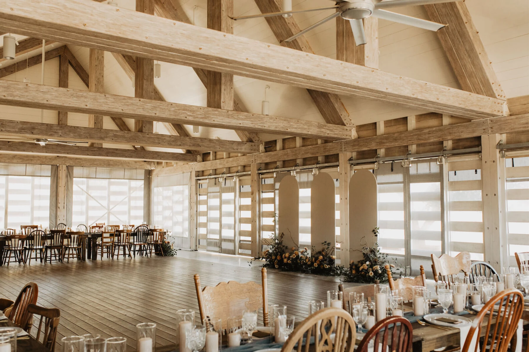 An indoor wedding ceremony where the reception tables set with mismatched chairs served as seating.