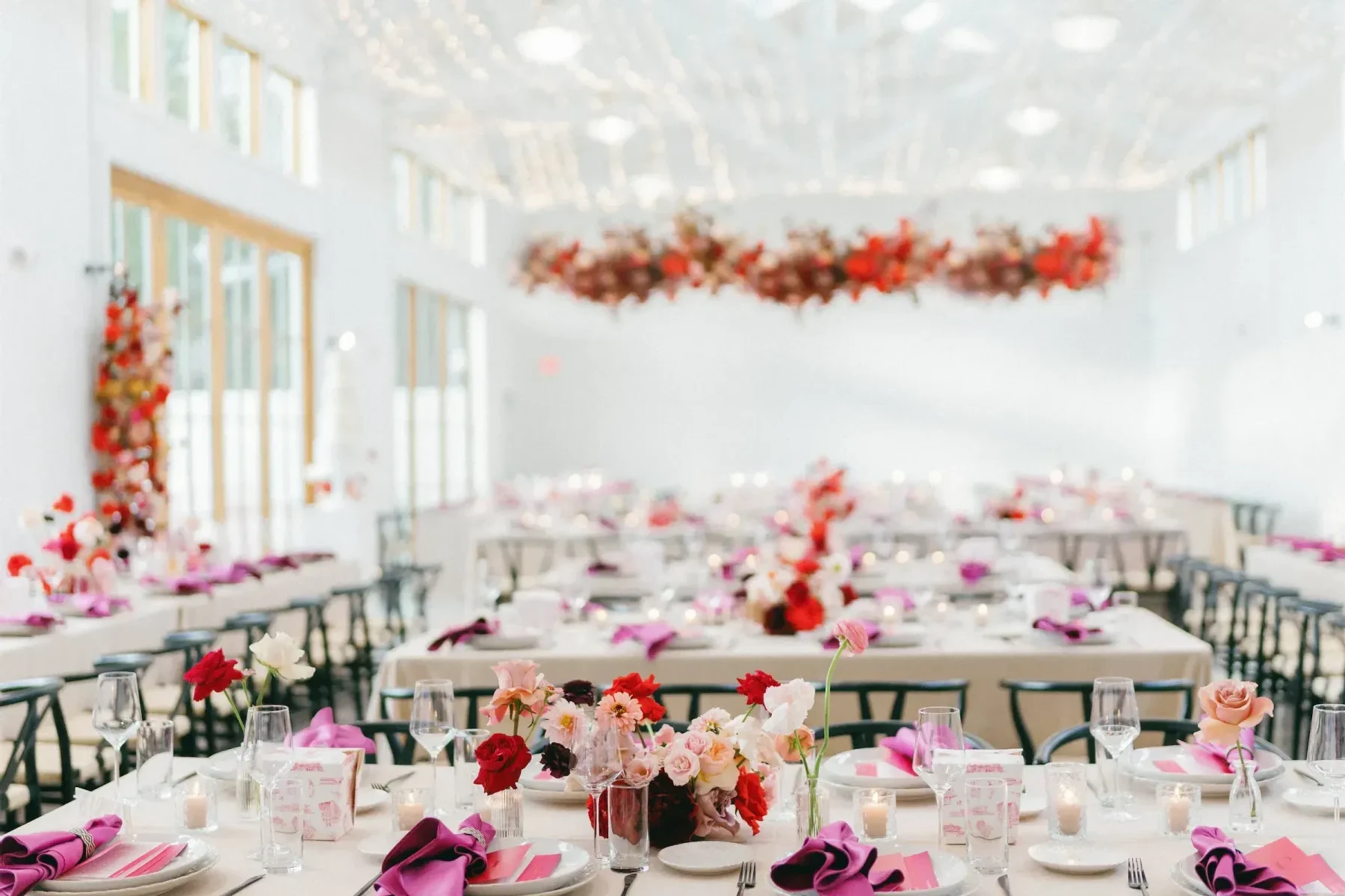 An indoor reception area with red and pink florals and decor.