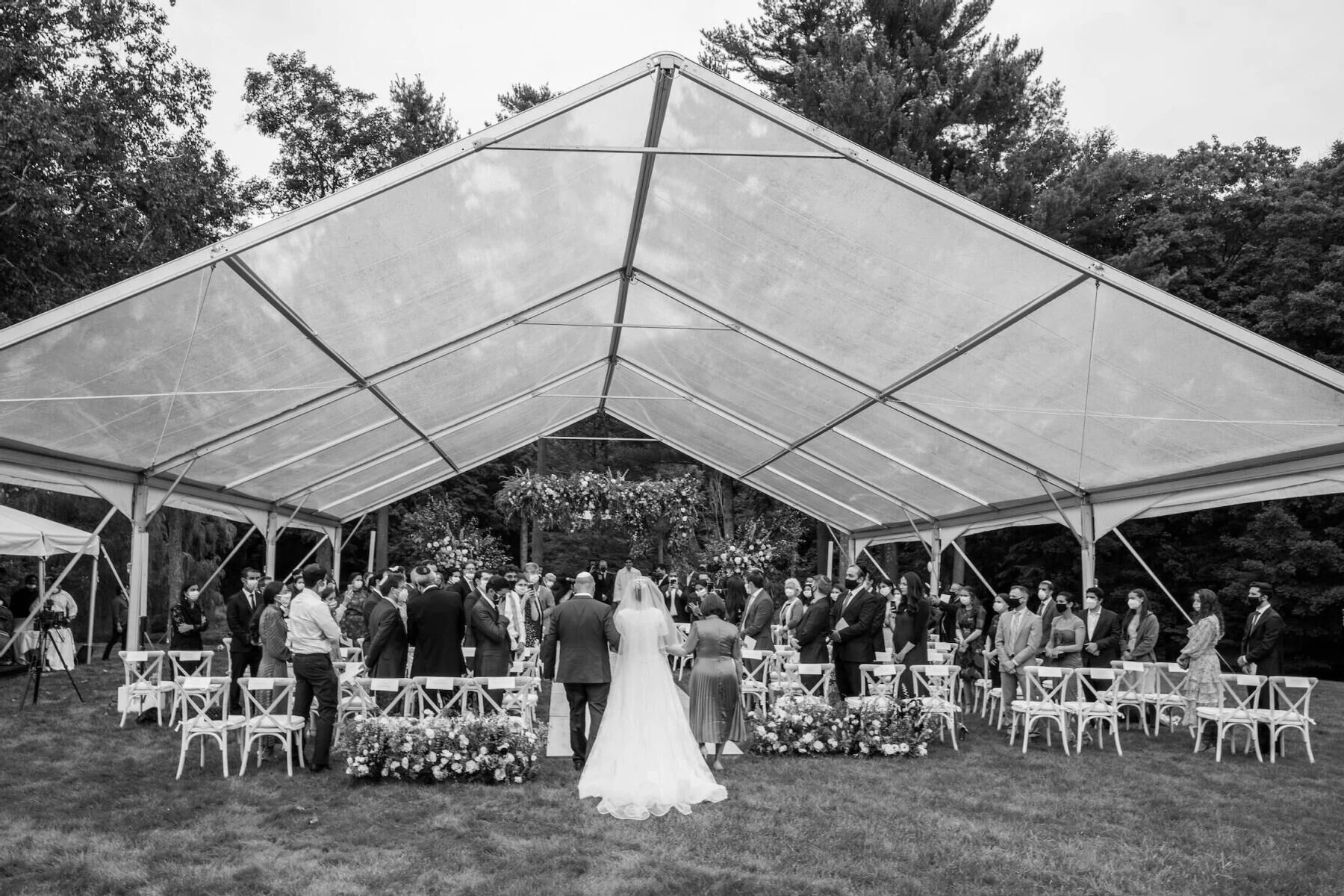 Wedding details: Bride being walked down the aisle by her father in an open air tented wedding ceremony at the Mayflower Inn and Spa