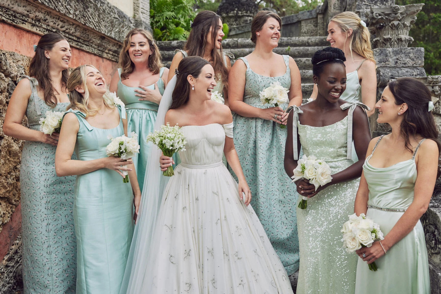 Wedding Dress Shopping: A bride laughing with her bridesmaids, who are all dressed in shades of green.