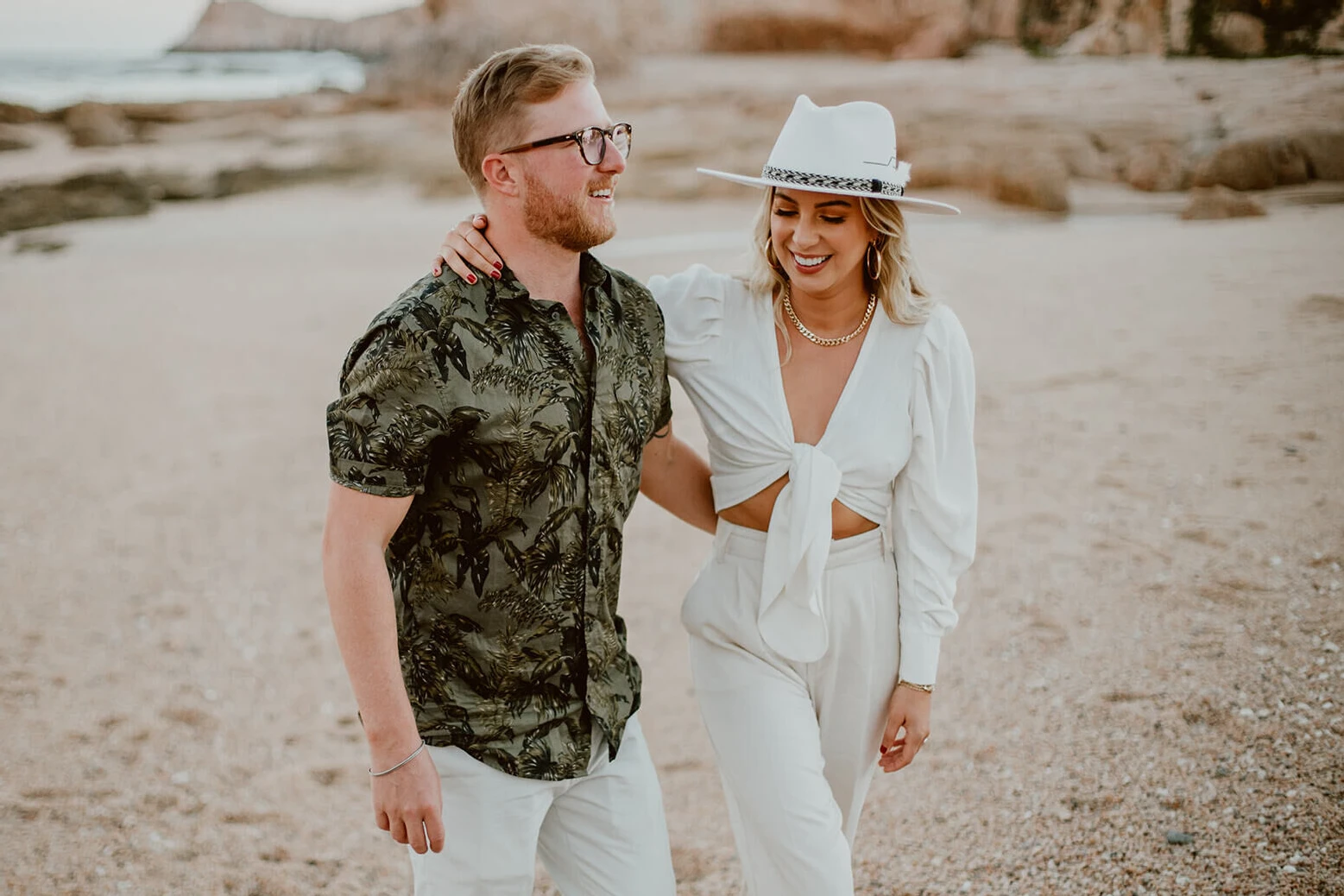 A groom and bride on the night before their Cabo wedding, wearing green and white attire befitting the beach setting.