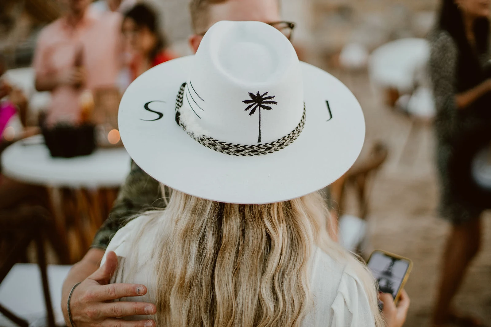 Initials and a palm tree logo emblazoned a hat worn by the bride at her welcome party.